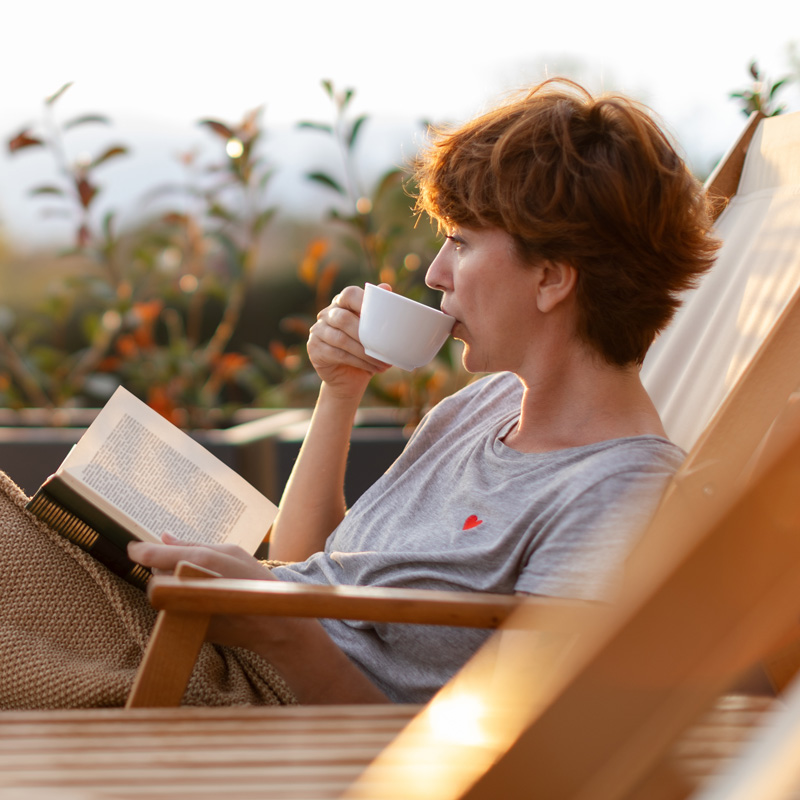 lady lounging in a chair with coffee and book